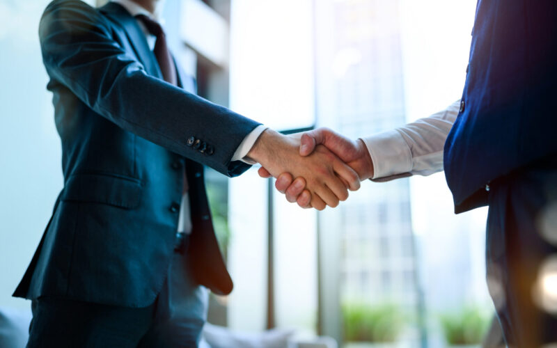 ビジネスパートナーとして握手する写真